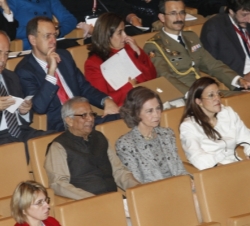 Su Majestad la Reina acompañada por la secretaria de estado de Cooperación Internacional, Soraya Rodríguez y el profesor Muhammad Yunus