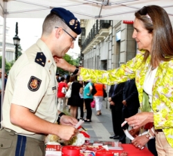 La Infanta impone la pegatina del Día de la Caridad a un miembro de la Guardia Real