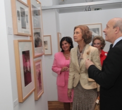 Su Majestad la Reina contempla una fotografía de la exposición