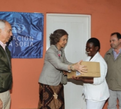 Su Majestad la Reina hace ebtrega de una caja de ayuda humanitaria durante su visita al Centro de Salud en el distrito de Namaacha
