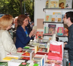 La Reina conversa con uno de los libreros durante su visita a la feria