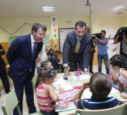 Su Majestad el Rey y el presidente de la Xunta de Galicia observan los trabajos de los niños durante su recorrido por el centro escolar