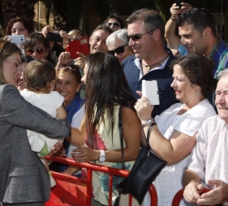 Doña Letizia a su llegada al Recinto Ferial de Zabra sostiene a una niña durante el saludo al público