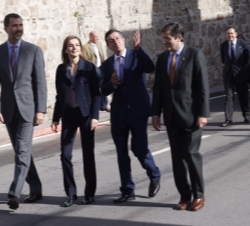 Sus Majestades los Reyes con el presidente del Principado de Asturias y el alcalde de Boal pasean por la calle Melquiades Álvarez, mientras observan l