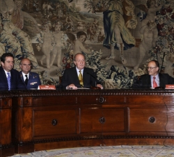 Don Juan Carlos en la mesa presidencia, acompañado por el gobernador del Banco de España, Luis María Linde, y el secretario de Estado de Economía y Ap