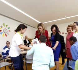 Doña Letizia recibe el trabajo de uno de los jóvenes usuarios de "Casa dos Marcos", en presencia de la Primera Dama de Portugal y la directo