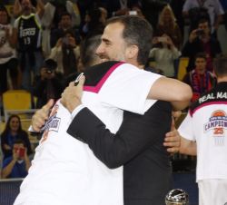 Su Majestad el Rey recibe el abrazo de Felipe Reyes tras entregarle la miniatura de la copa de campeón