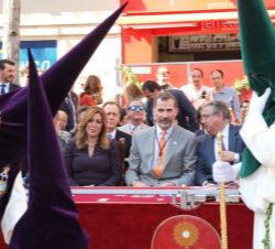 Su Majestad el Rey, junto a la presidenta de la Junta de Andalucía y el alcalde de Sevilla, al paso de los nazarenos de la Hermandad de la Redención e
