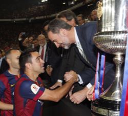 Su Majestad el Rey recibe el saludo de los capitanes del Fútbol Club Barcelona, Xavi Hernández y Andrés Iniesta, antes de entregarles la copa de campe