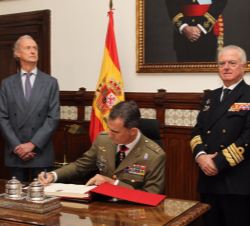 Su Majestad el Rey firma en el Libro de Honor, en presencia del ministro de Defensa y el gran canciller de la Real y Militar Orden de San Hermenegildo