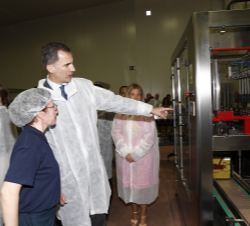 Don Felipe recibe explicaciones sobre la planta embotelladora durante el recorrido por las instalaciones de la Cooperativa Virgen de las Viñas