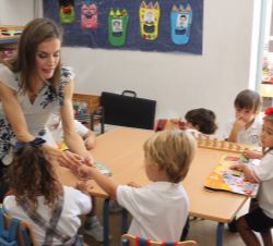 Su Majestad la Reina durante su visita al C.E.I.P. "Ginés Morata", conversa con unos niños