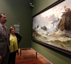Su Majestad el Rey observa uno de los cuadros expuestos durante su visita a las salas de Pintura del Museo