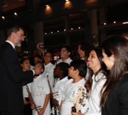 Don Felipe felicita a los jóvenes miembros de la orquesta "La música del reciclaje de Ecoembes", que ofreció una actuación musical durante e