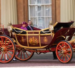 Su Majestad el Rey junto a la Reina de Inglaterra llegan en un coche de caballos al Palacio de Buckingham