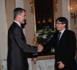 Don Felipe recibe el saludo del presidente de la Generalitat de Cataluña, Carles Puigdemont, a su llegada al Palacio Albéniz