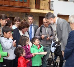 Su Majestad el Rey conversa con unos niños de la localidad asturiana de Somiedo