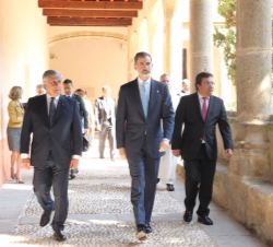 Don Felipe junto al galardonado Antonio Tajani y al presidente de la Junta de Extremadura acceden al interior del Monasterio de Yuste