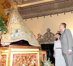 Sus Majestades los Reyes en el presbiterio cumplen con la tradición de tocar el manto de la Virgen