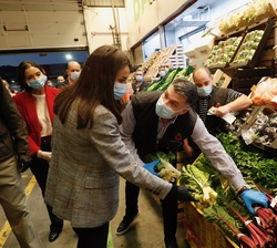 Doña Letizia conversa con un empleado de un puesto de las naves de frutas y verduras