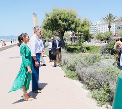 Don Felipe y Doña Letizia conversan con algunos turistas durante su paseo por el paseo marítimo