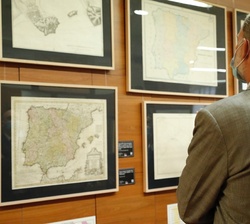 Don Felipe observa unos mapas durante su recorrido por la exposición