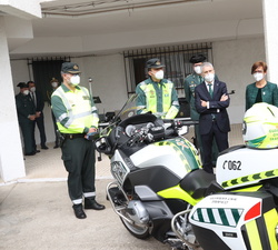 Su Majestad el Rey conversa con dos Guardias Civiles de la Unidad de Tráfico, en presencia del ministro del Interior y de la directora general de la G