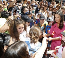 Su Majestad la Reina recibe un caluroso saludo de unos niños durante su recorrido por la Feria del Libro de Madrid