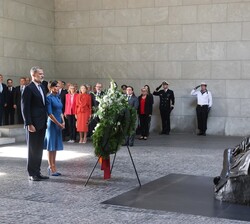Sus Majestades los Reyes durante el minuto de silencio, ante la estatua de bronce “Madre con hijo muerto”, de la escultora alemana Käthe K