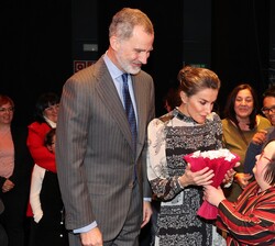 Sus Majestades los Reyes reciben un regalo de una de los asistentes a la inauguración de la Farmacia Llabrés