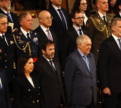 Sus Majestades los Reyes, acompañados por las autoridades asistentes al acto, en el momento de la interpretación del Himno Nacional