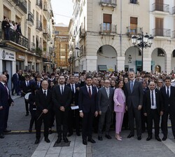 Fotografía de grupo de Sus Majestades los Reyes y las autoridades junto al público en la plaza del Ayuntamiento