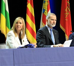 Su Majestad el Rey ocupa su lugar en la mesa presidencial  