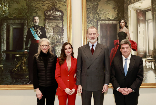 Sus Majestades los Reyes acompañados por el gobernador del Banco de España, José Luis Escrivá y la artista Annie Leibovitz, delante de sus retratos re
