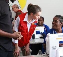 Doña Letizia se interesa por el trabajo que realizan las mujeres beneficiarias del proyecto en el taller