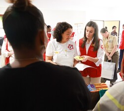 Su Majestad la Reina observa el trabajo realizado en el taller de costura del Proyecto 'Kredita Na Bo'