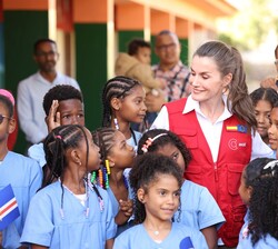 Doña Letizia conversa con los alumnos que van a plantar verduras en el patio