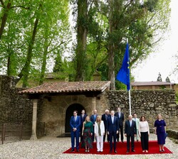 Su Majestad el Rey, acompañado del premiado y de las autoridades asistentes al acto bajo la enseña de la Unión Europea