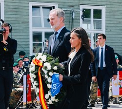 Don Felipe y Doña Letizia se dirigen hacia el monumento portando la corona de flores