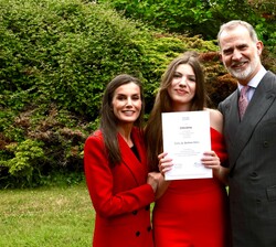 Fotografía de familia de Sus Majestades los Reyes y Su Alteza Real la Infanta Sofía mostrando orgullosa su diploma de Bachillerato Internacional