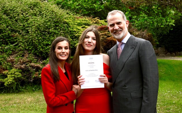 Fotografía de familia de Sus Majestades los Reyes y Su Alteza Real la Infanta Sofía mostrando orgullosa su diploma de Bachillerato Internacional