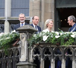 Fotografía de Su Majestad el Rey en el balcón de la escalera de la escalera principal del Ayuntamiento de Aquisgrán junto a la laureada, Úrsula Von de