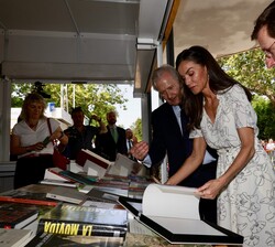 Su Majestad la Reina hojea un libro en la caseta del Ayuntamiento de Madrid