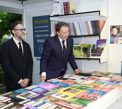 Su Majestad la Reina conversa con Paulo Cossin, director editorial y Federico Ruozzi, presidente de Reggio Children, en la caseta de Ediciones Morata
