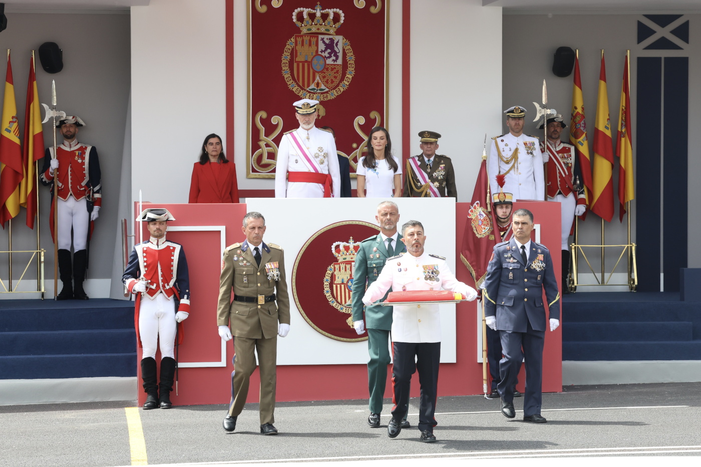 Sus Majestades los Reyes en la Tribuna Real durante el traslado de la Enseña Nacional portada por tres Guardias Reales y un Guardia Civil de la Casa d
