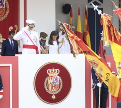 Sus Majestades los Reyes en la Tribuna Real durante el desfile de unidades a pie al paso de la Enseña Nacional