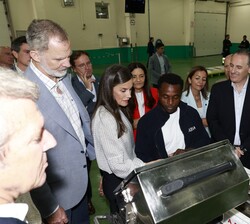 Sus Majestades los Reyes atienden a las explicaciones de uno de los trabajadores de la Lonja