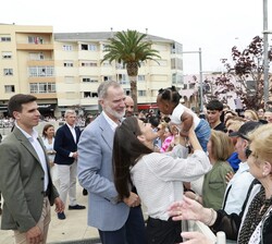 Doña Letizia coge en brazos a una niña que se encontraba entre el público bajo la atenta mirada de Su Majestad el Rey