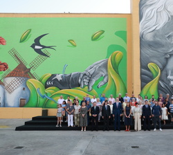 Fotografía de grupo de Sus Majetades los Reyes con una representación debadienses frente al mural participativo que rinde homenaje a Badia del Vallès
