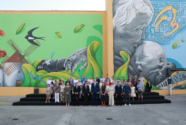Fotografía de grupo de Sus Majetades los Reyes con una representación debadienses frente al mural participativo que rinde homenaje a Badia del Vallès